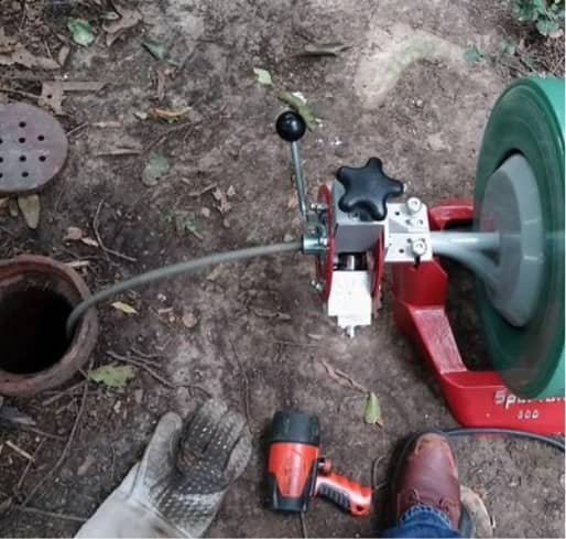 Plumber using high-pressure jetting to clear a blocked kitchen drain in Randwick home
